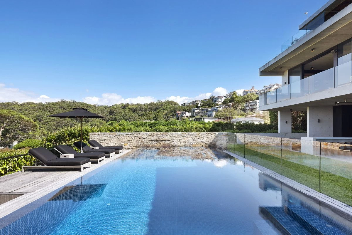 Outdoor swimming pool with clear water, lounge chairs, and scenic views - 16 Iluka Road, Mosman, NSW 2088