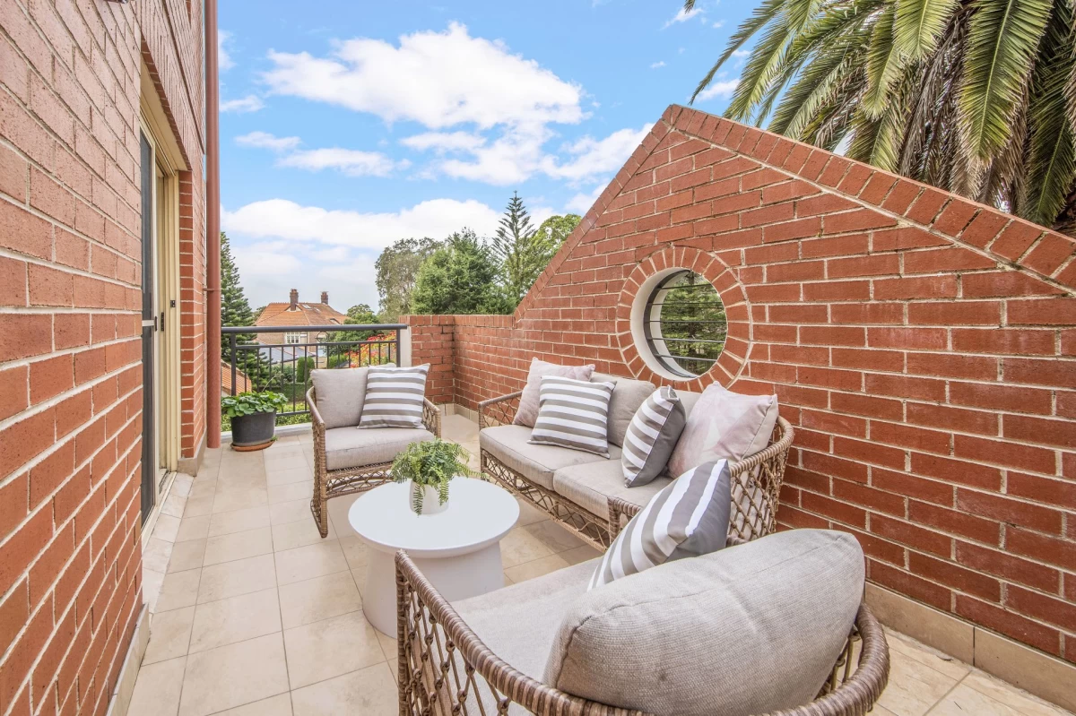 Cosy balcony with seating area and potted plants, accessed from the living room - 18/69 Bradleys Head Road, Mosman, NSW 2088