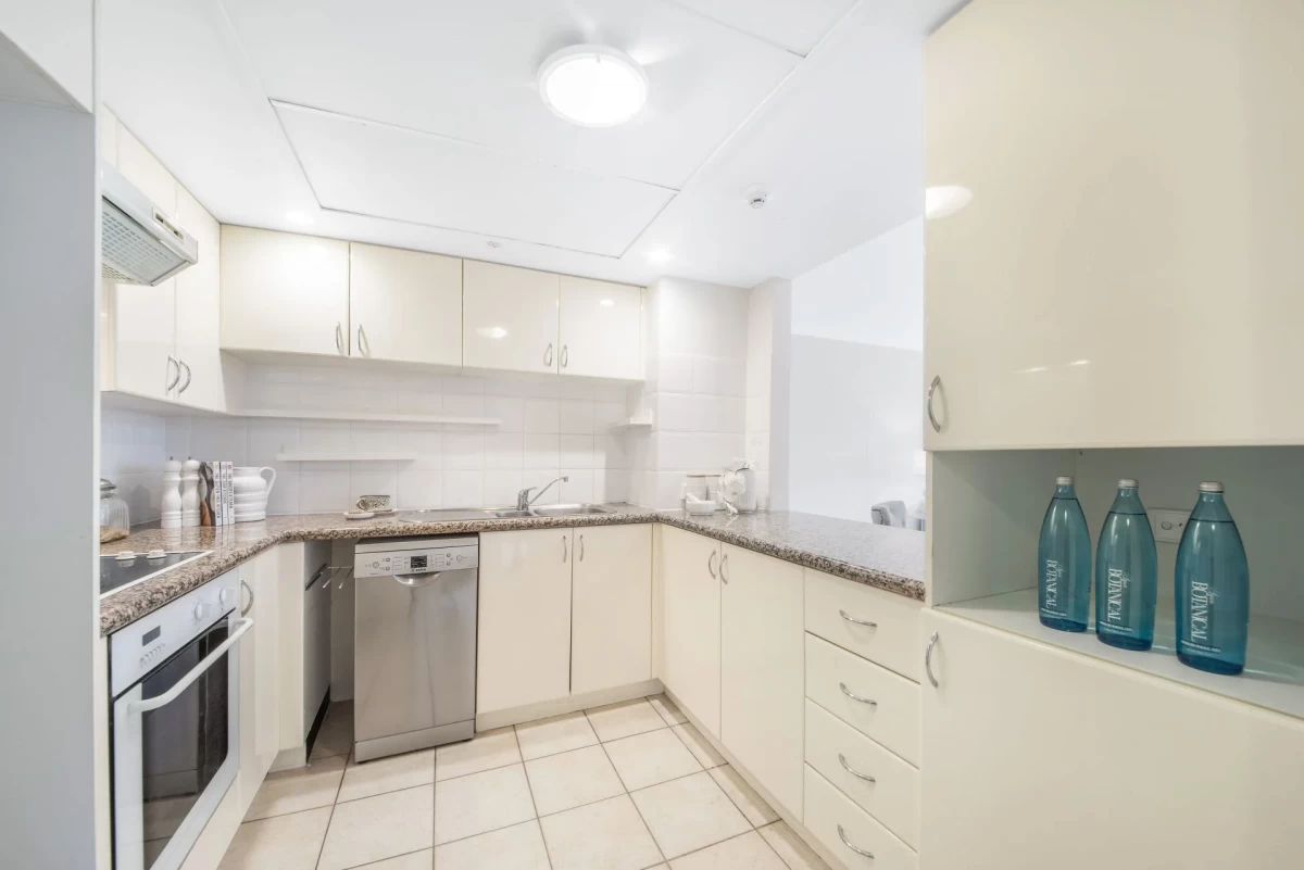 Functional L-shaped kitchen with modern appliances and white cabinets for ample storage - 18/69 Bradleys Head Road, Mosman, NSW 2088