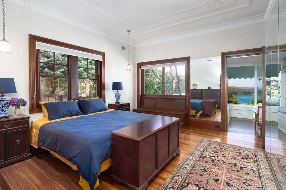 Master bedroom with a large bed, windows, and additional seating area - 215A Spit Road, Mosman, NSW 2088