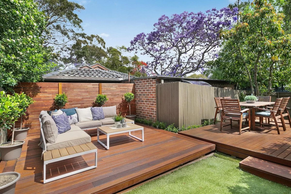 Two-level outdoor deck with seating and dining areas, surrounded by greenery - 32 Phoenix Street, Lane Cove, NSW 2066