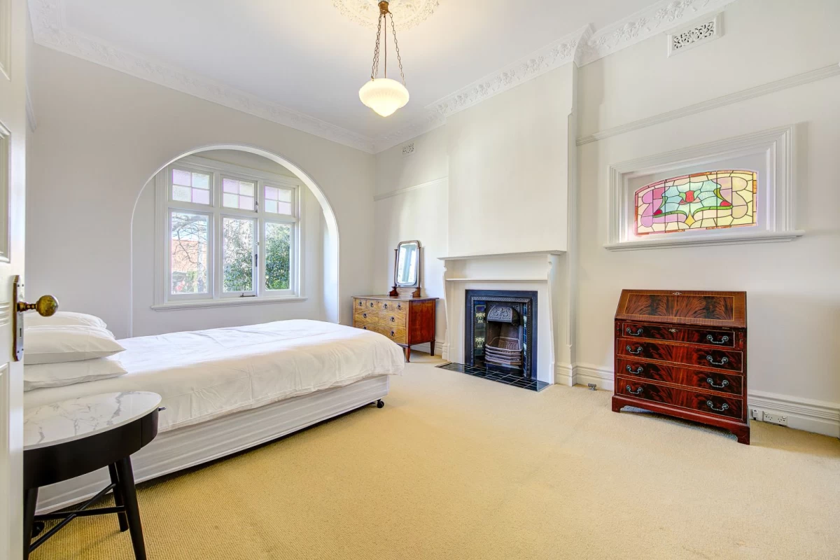 Spacious bedroom with large window, fireplace, and stained-glass window - 39 Cabramatta Road, Mosman, NSW 2088