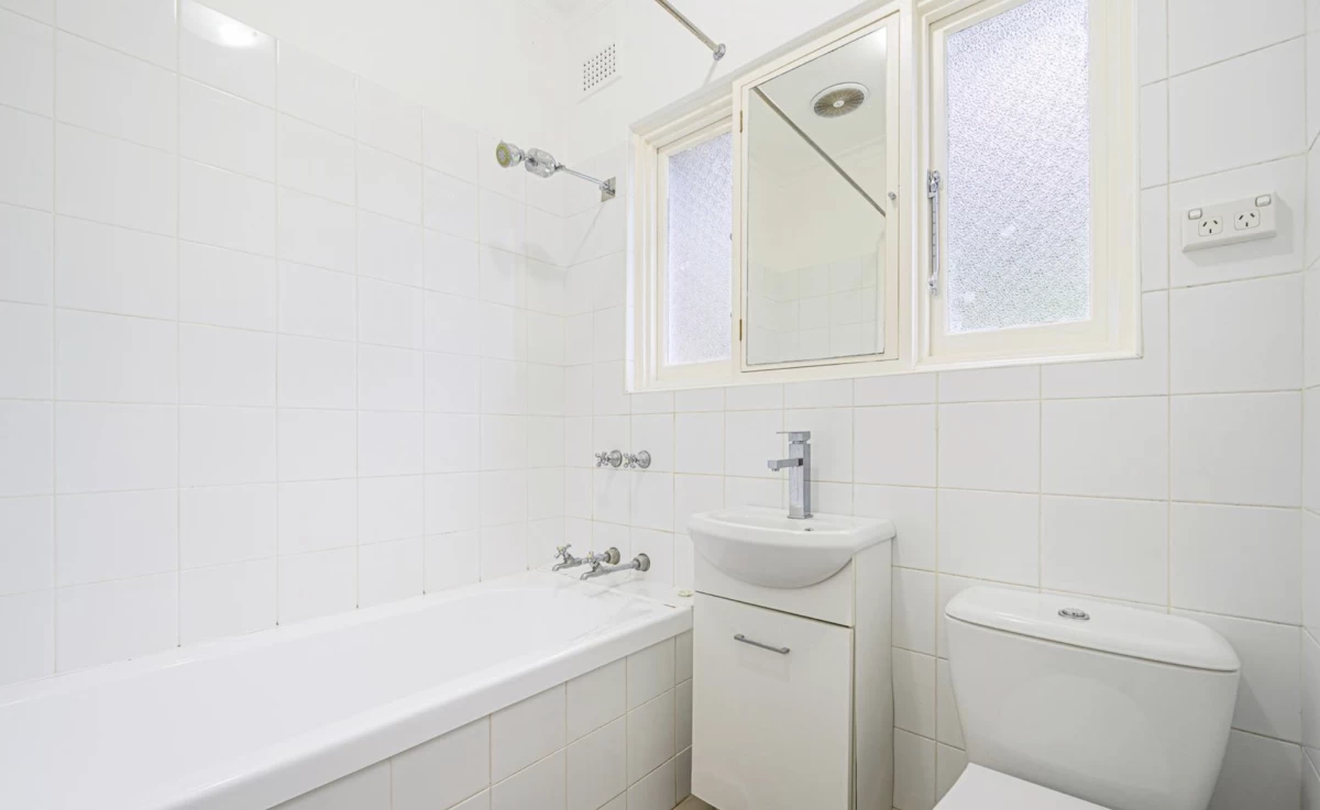 White-tiled bathroom with bathtub and sink cabinet - 4 Morrice Street, Lane Cove, NSW 2066