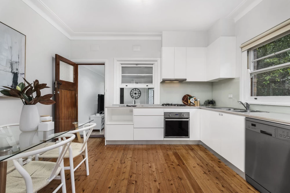 Bright kitchen with white cabinets, wooden floor, and silver appliances - 45 Bridge Street, Lane Cove, NSW 2066