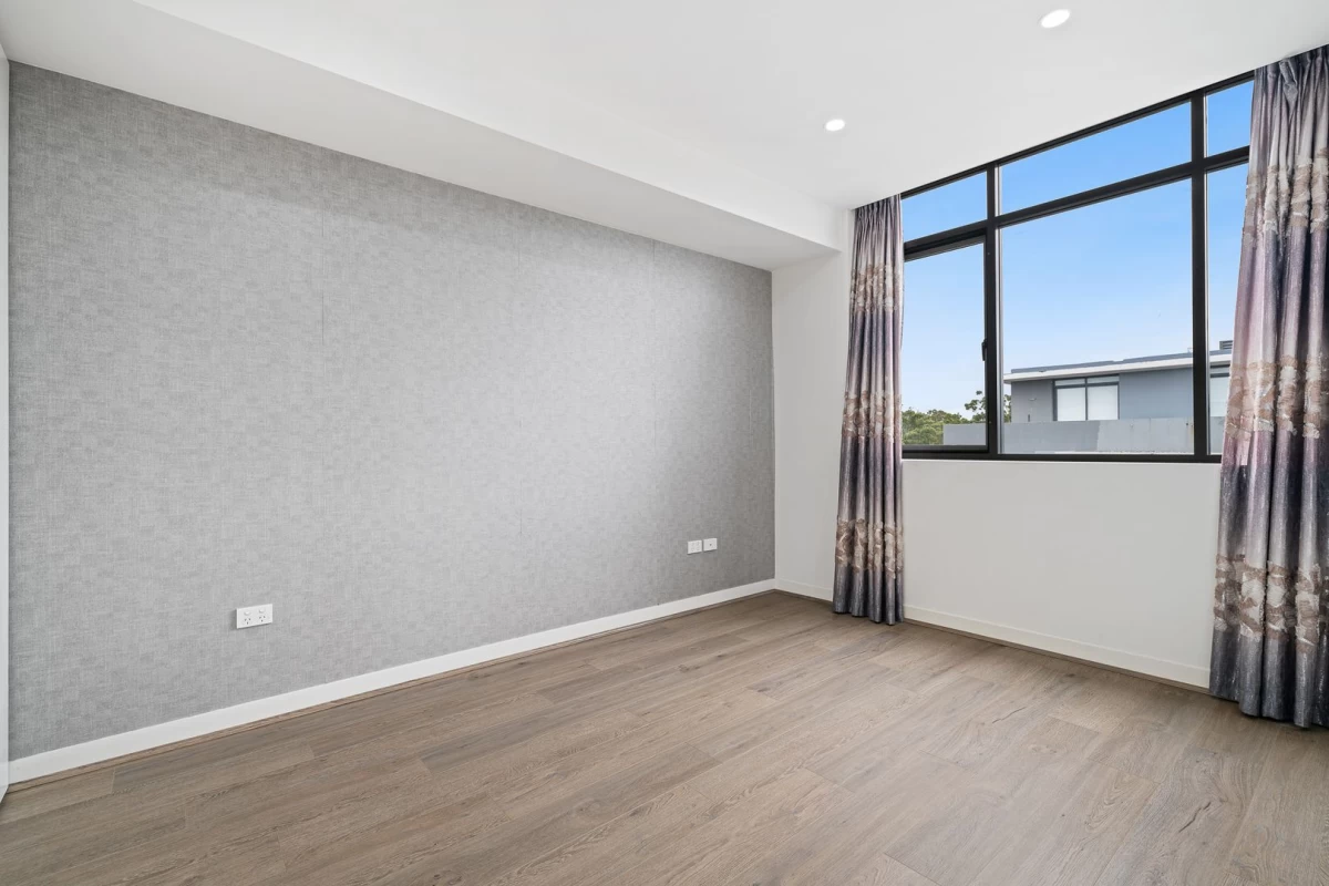 Well-lit bedroom with large window and grey accent wall - 704/10 Waterview Drive, Lane Cove, NSW 2066