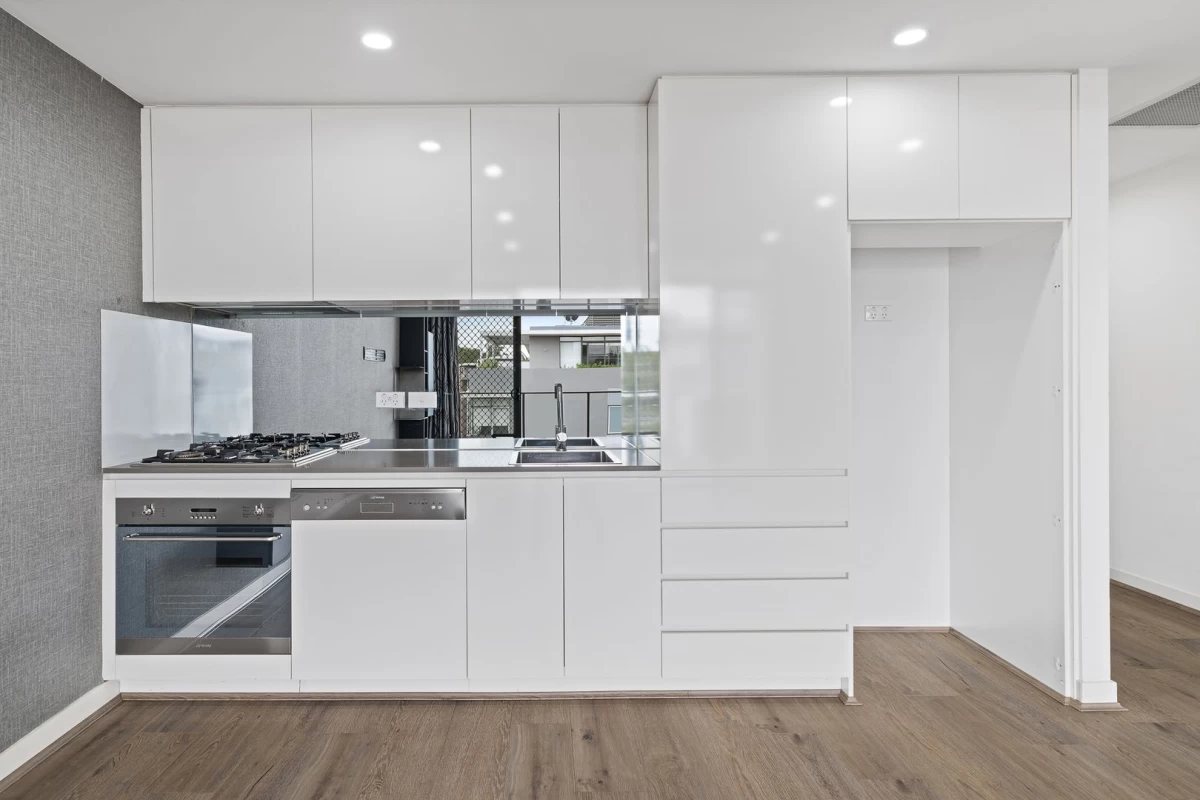 Modern kitchen with white cabinets and stainless steel appliances - 704/10 Waterview Drive, Lane Cove, NSW 2066